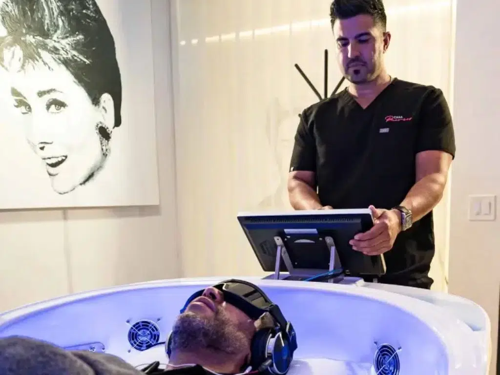 Skilled luxury medical technician at Casa Privee sets up a theta chamber in Miami. Session for treating addiction, stress, insomnia, and more.